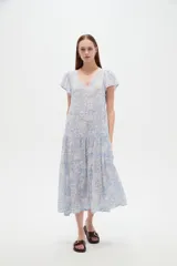 Vestido midi de viscosa con estampado floral en tonos celeste y blanco, cuello en V, mangas cortas y diseño holgado con volados escalonados en la falda.