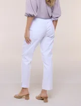 Pantalón ankle de tiro alto color blanco, confeccionado en tejido elástico con pretina ancha tipo pull-on, corte entallado y detalle de encaje calado en las aberturas laterales del ruedo.