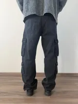 Pantalón tipo jean cargo de corte baggy, color celeste claro, con múltiples bolsillos laterales y cierre frontal.