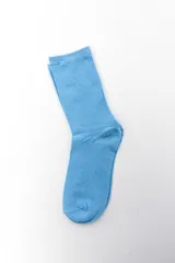 Pack de dos pares de medias crew de algodón con diseños estampados, combinando un par liso en color celeste y otro con patrón de ondas y detalles en verde o rosado.