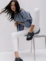 Pantalón jean skinny blanco de tiro alto, con cierre de botón y cremallera.