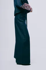 Pantalón wideleg de denim azul oscuro, de tiro alto y corte amplio con bolsillos laterales y cinturón incorporado.