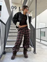 Campera tipo gamulán de cuero sintético negro con interior y detalles de corderito blanco. Presenta cierre frontal, bolsillos laterales y diseño holgado.