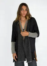 Saco abierto de tejido de punto grueso color azul con diseño de rayas horizontales en tonos grises y marrones.