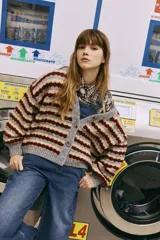 Cardigan de punto con diseño de rayas horizontales en tonos gris, beige y bordó. Presenta un calce relajado, silueta amplia, mangas largas y cierre frontal con botones grandes.