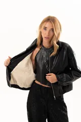 Campera de cuero sintético color negro, con cierre frontal, cuello clásico y bolsillos laterales con broches metálicos.