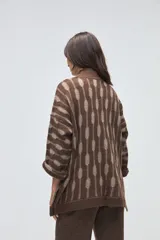 Saco abierto de tejido de punto en color marrón con diseño de rayas verticales abstractas en tono beige. Presenta mangas tres cuartos y un corte holgado.