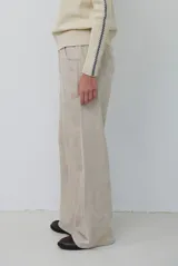 Pantalon de pana color beige, de corte recto y tiro alto, con bolsillos laterales y cintura elástica.