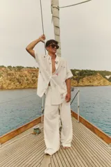 Camisa oversize de manga corta con cierre frontal de botones. Presenta un estampado integral con motivos náuticos y elementos gráficos.