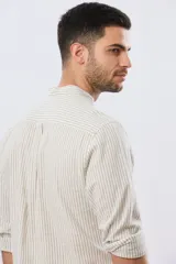 Camisa de lino a rayas verticales blancas y azules, de manga larga, con cuello mao y cierre frontal de botones.