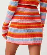 Minifalda tejida a crochet con rayas horizontales de colores contrastantes.