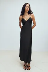 Vestido midi de tejido satinado color negro, con escote en pico, tirantes finos ajustables y diseño de espalda con tiras cruzadas.