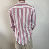 Camisa celeste y blanca a rayas verticales, de lino, con cuello mao y mangas largas con puños.