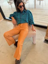 Camisa de corte oversize con estampado a cuadros en tonos verde y azul. Presenta mangas abullonadas con puños elásticos y cierre frontal con botones.