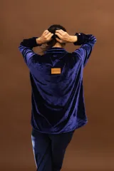 Camisa de terciopelo azul marino, de manga larga con puños abotonados y bolsillos frontales con solapa.