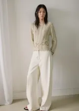 Buzo de punto medio de algodón color beige con diseño recto, detalles calados con patrón en zigzag, cuello redondo y manga larga.