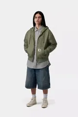 Campera puffer negra de tafetán de nailon reciclado, con capucha ajustable, cierre frontal bidireccional y bolsillos tipo canguro. Presenta puños y dobladillo de punto acanalado y detalle de etiqueta cuadrada tejida en el bolsillo.
