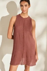 Vestido corto de lino italiano, sin mangas y con cuello redondo, en color bordó. Presenta detalles desflecados en el cuello, en el ruedo y a lo largo de una costura vertical frontal.