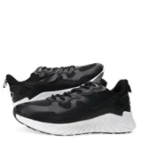 Championes deportivos de hombre en color negro, con diseño de paneles superpuestos en material sintético y malla, cierre mediante cordones y suela blanca con relieve estriado.