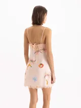 Vestido mini de seda de viscosa con estampa exclusiva de motivos frutales, escote en V con detalle de puntilla, breteles finos y tajo lateral en el ruedo.