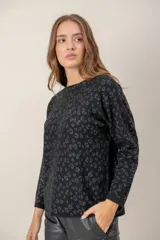 Sweater de punto con diseño de animal print en tonos oscuros, cuello redondo y mangas largas con puños acanalados.