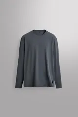 Camiseta de entrenamiento de ajuste regular, color gris oscuro, con cuello redondo y manga larga. Confeccionada en tejido técnico ligero y elástico con estructura, y costuras planas.