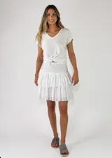 Minifalda blanca con cintura elástica fruncida tipo smock y dos volados escalonados en la falda.