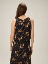 Top negro sin mangas con estampado geométrico y manchas texturizadas en tonos marrones y beige, con silueta balloon.