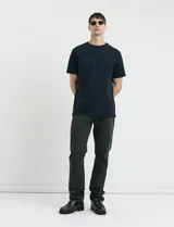 Pantalón de algodón sarga con elastano, diseño de cinco bolsillos, cierre frontal con botones de metal en tono plata viejo y bolsillos traseros de parche.