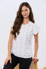 Blusa blanca sin mangas con volados en los hombros, cuello redondo con aberturas y cierre frontal parcial con botones.