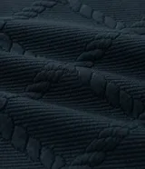 Buzo de cuello redondo y manga larga, confeccionado en tejido de poliéster con textura de cuerdas en relieve y puños acanalados.