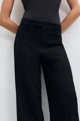 Pantalón de tiro medio color tostado, con pernera recta, trabillas para cinturón y cierre frontal con cremallera y botón oculto.