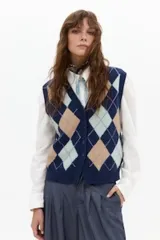 Chaleco de punto con diseño de rombos argyle en tonos gris, beige, marrón y verde, con escote en V y cierre frontal de botones.