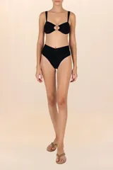 Top de bikini bandeau negro con corte circular y aberturas con cuentas doradas al centro. Breteles semi-amplios y ajustables en la espalda, con recogidos laterales.