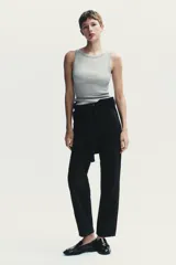 Jeans de mujer, tiro alto, color azul medio con efecto desgastado (lavado claro en muslos y oscuro en bordes). Corte recto y ancho (mom fit) con cinco bolsillos y cierre frontal de botón y cremallera.