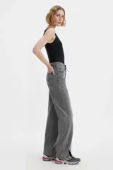 Jean de corte baggy y tiro medio, con diseño de costuras retorcidas y abertura en el ruedo. Presenta cierre de botones a la vista y un acabado lavado en tono gris.