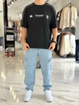 Remera regular color off-white, con diseño gráfico en la espalda que incluye el número 99 en gran tamaño y detalles en negro. Cuenta con ribetes negros en las costuras de los hombros y mangas.