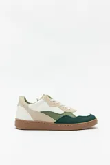 Zapatillas deportivas con recortes en símil cuero y gamuza de colores blanco, beige, verde claro y verde oscuro. Suela de goma color caramelo.