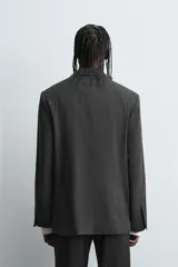 Blazer de corte relajado con diseño a rayas verticales, cuello con solapas de muesca y manga larga. Presenta cierre frontal de botonadura cruzada, bolsillos con solapa en la cadera y aberturas en la espalda.