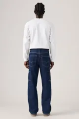 Jeans de denim azul oscuro con corte holgado y recto, estilo carpintero, con trabillas para cinturón y bolsillos funcionales.