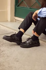 Mocasines negros de cuero con cordones y suela track.