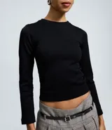 Remera de manga larga con cuello redondo y diseño ajustado al cuerpo. Presenta una textura canelada y un acabado suave al tacto, confeccionada en microfibra elástica.