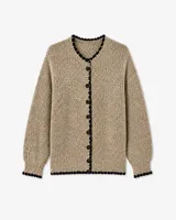 Cardigan de punto en color beige con textura tejida, cuello redondo y cierre frontal de botones. Presenta un detalle de borde festoneado en color negro en el cuello, la tapeta de botones, el ruedo y los puños.
