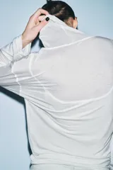 Camiseta blanca de manga larga con cuello alto y calce oversize. Incluye un top interior del mismo tejido.