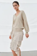 Jersey de lana color beige, con escote en pico y manga larga.