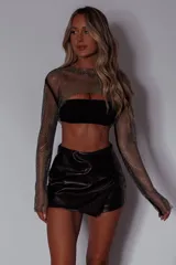 Manguitas largas de malla negra con incrustaciones de strass o brillos, cuello redondo y puños ajustados.