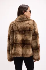 Campera de piel sintética con diseño de franjas horizontales en tonos marrones. Presenta solapas amplias, cierre frontal oculto y mangas largas de corte recto.