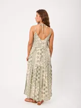 Vestido largo de algodón con estampado estilo patchwork en tonos verde y beige, escote en V con tirantes finos ajustables, diseño holgado y falda escalonada con bolsillos laterales.