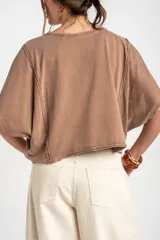 Remera oversize de algodón blanco crudo, con cuello redondo y mangas cortas anchas de corte relajado.