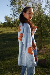 Cárdigan celeste pálido de lana merino con bordados florales color ladrillo hechos a mano.